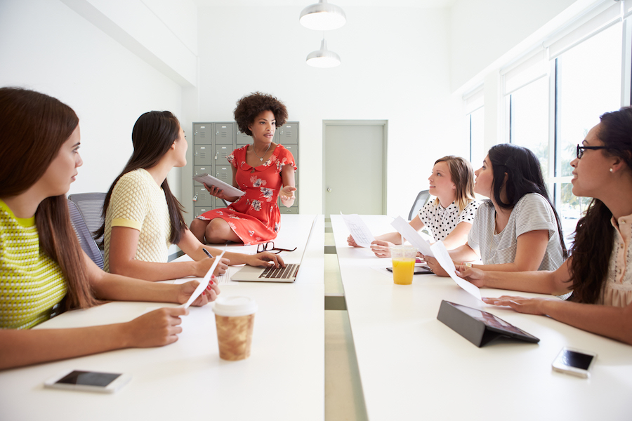A manager leads a development session for women in a call center.